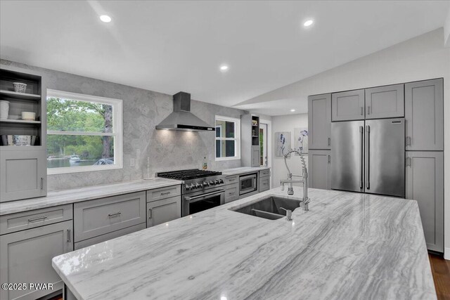 105 Cherry Point Ct, Hawley, PA 18428 - kitchen with high end appliances, wall chimney range hood, a sink, gray cabinets, and light stone counters