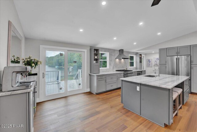 105 Cherry Point Ct, Hawley, PA 18428 - kitchen featuring wall chimney exhaust hood, gray cabinetry, a sink, high end appliances, and light stone counters
