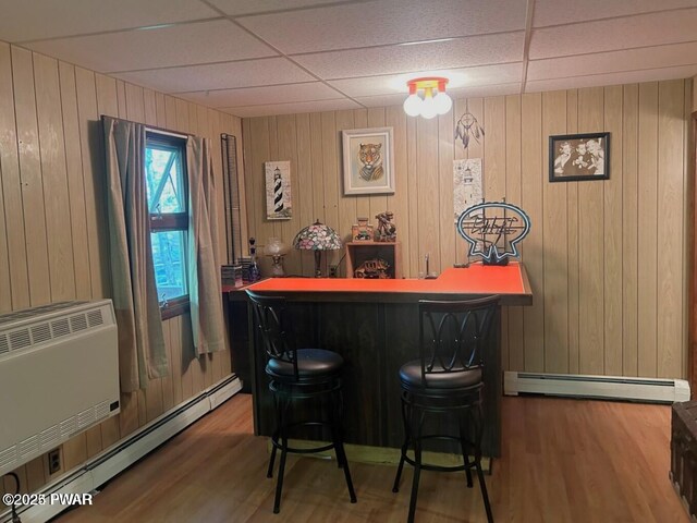 106 Chestnut Dr, Greentown, PA 18426 - indoor dry bar featuring a baseboard heating unit, a paneled ceiling, wood finished floors, and wooden walls