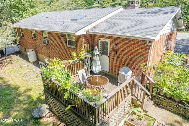 rear view of property featuring a deck and cooling unit