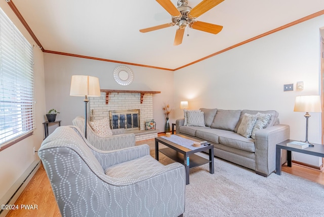 living room featuring ceiling fan, a brick fireplace, a baseboard heating unit, crown molding, and light hardwood / wood-style floors