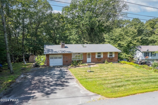 view of front of house featuring a garage, a front lawn, and a storage shed