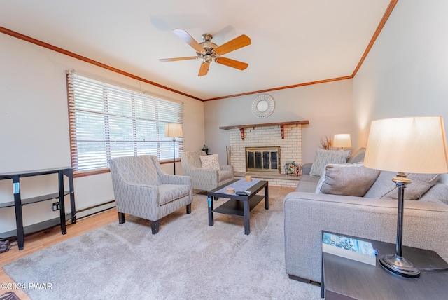 living room featuring ceiling fan, ornamental molding, light wood-type flooring, and a brick fireplace