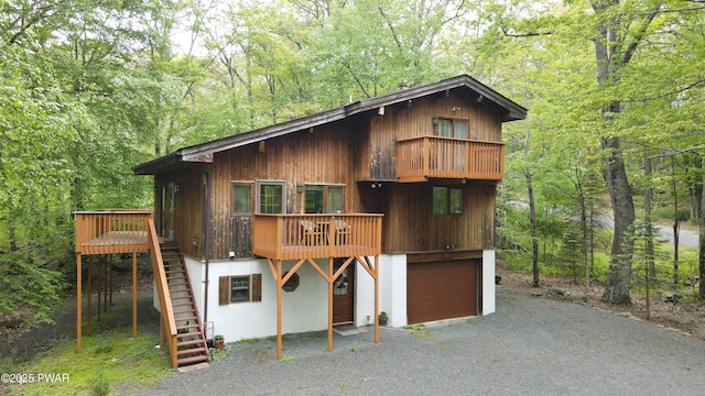 404 Canoebrook Dr, Lords Valley, PA 18428 - view of front of home with stairway, a forest view, gravel driveway, and a garage