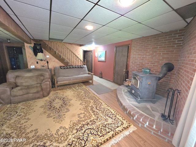 1304 Pratt Hollow Rd, Nicholson, PA 18446 - living room featuring a wood stove, wood finished floors, stairway, and a paneled ceiling