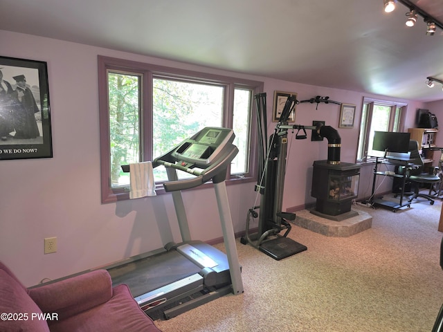 1304 Pratt Hollow Rd, Nicholson, PA 18446 - exercise room featuring plenty of natural light, rail lighting, carpet floors, and a wood stove