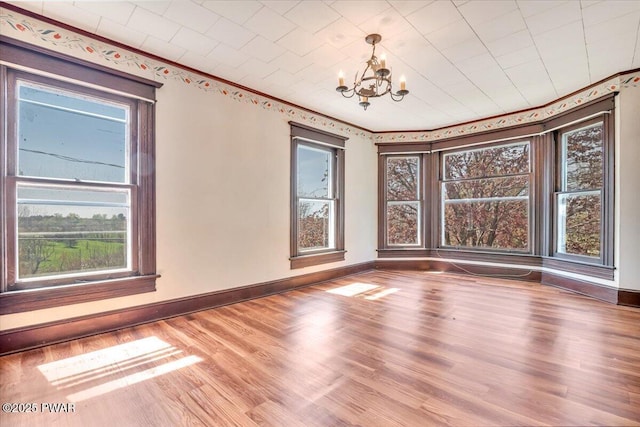 1409 Beach Lake Hwy, Beach Lake, PA 18405 - empty room with plenty of natural light, baseboards, wood finished floors, and a notable chandelier