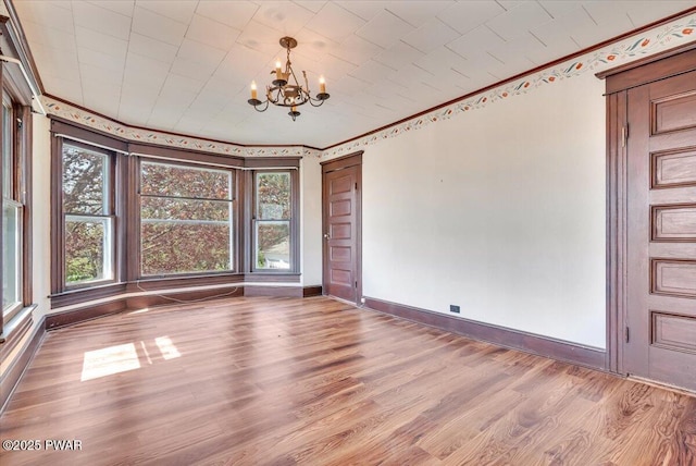 1409 Beach Lake Hwy, Beach Lake, PA 18405 - unfurnished dining area with baseboards, ornamental molding, wood finished floors, and a chandelier