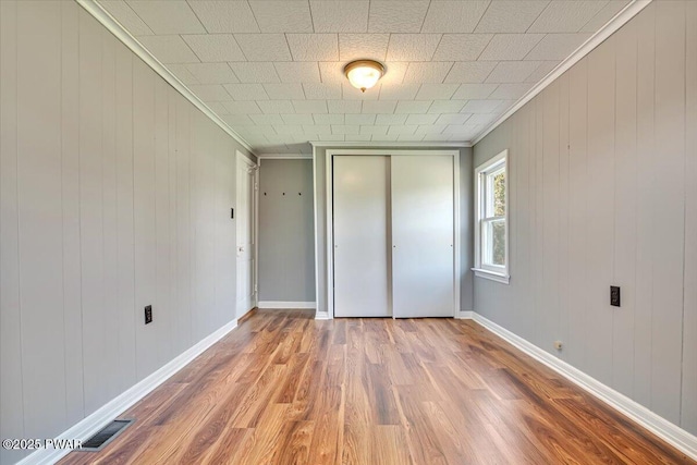 1409 Beach Lake Hwy, Beach Lake, PA 18405 - unfurnished bedroom with visible vents, ornamental molding, wood finished floors, and a closet