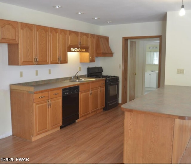 kitchen featuring sink, black appliances, light hardwood / wood-style floors, and premium range hood