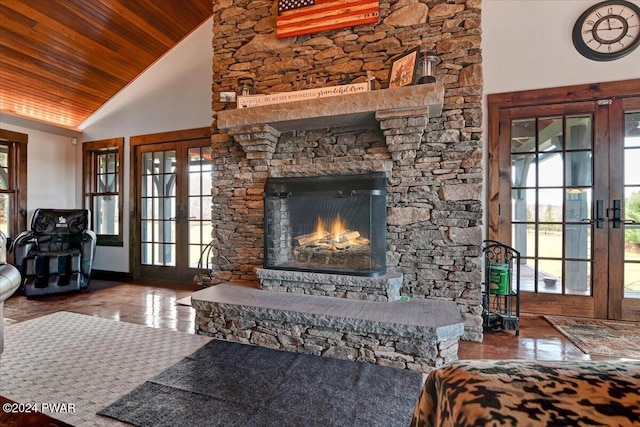 tiled living room featuring french doors, a healthy amount of sunlight, a stone fireplace, high vaulted ceiling, and wood ceiling