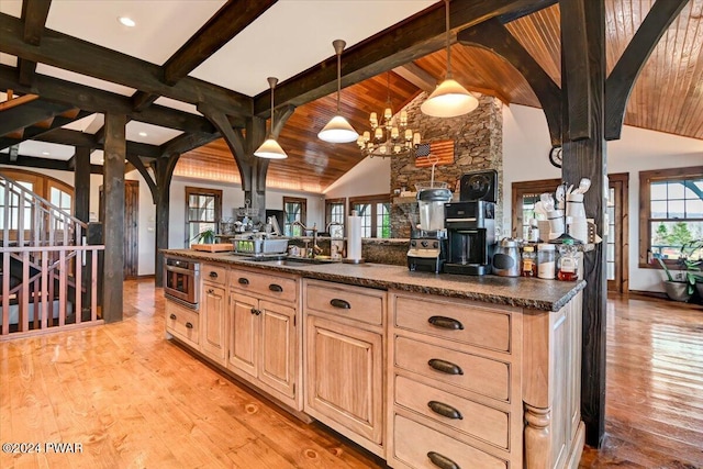 kitchen with light brown cabinets, hanging light fixtures, a healthy amount of sunlight, and sink