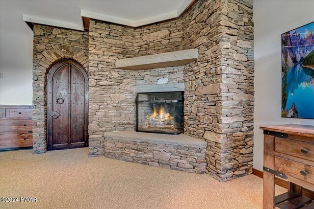 unfurnished living room featuring a fireplace and carpet flooring