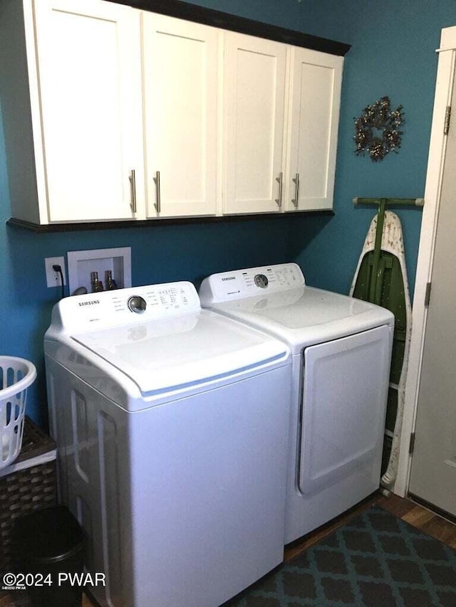 laundry room with dark wood-type flooring, independent washer and dryer, and cabinet space