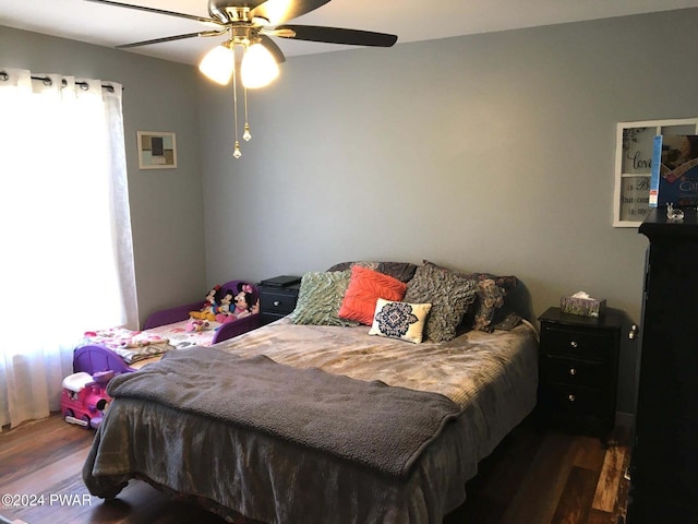 bedroom featuring multiple windows, ceiling fan, and wood finished floors