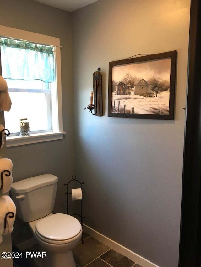 bathroom with baseboards, toilet, and tile patterned floors