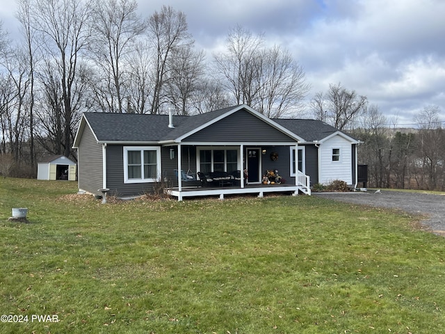 view of front facade featuring a porch, a shed, and a front yard