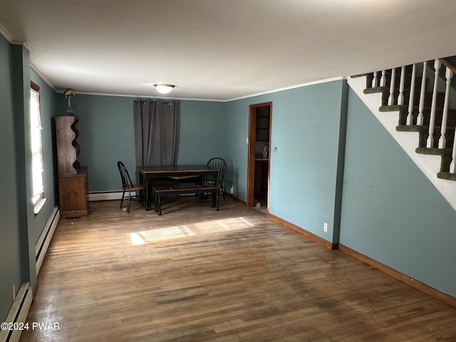 dining area with a baseboard radiator, crown molding, and wood finished floors