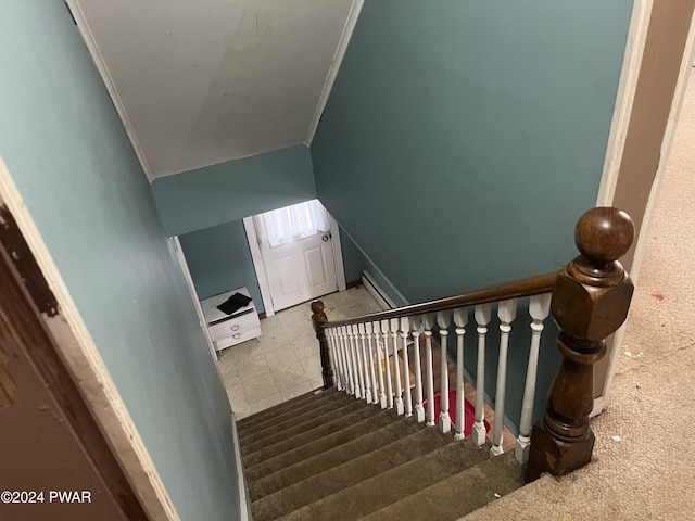 stairs featuring vaulted ceiling and crown molding