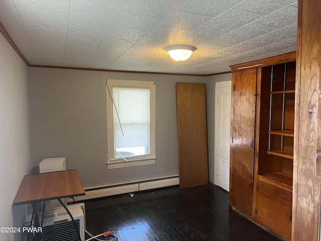 empty room featuring a wall unit AC, hardwood / wood-style flooring, a baseboard heating unit, and ornamental molding