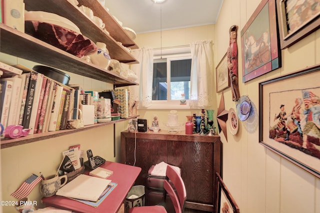 home office featuring crown molding and wooden walls