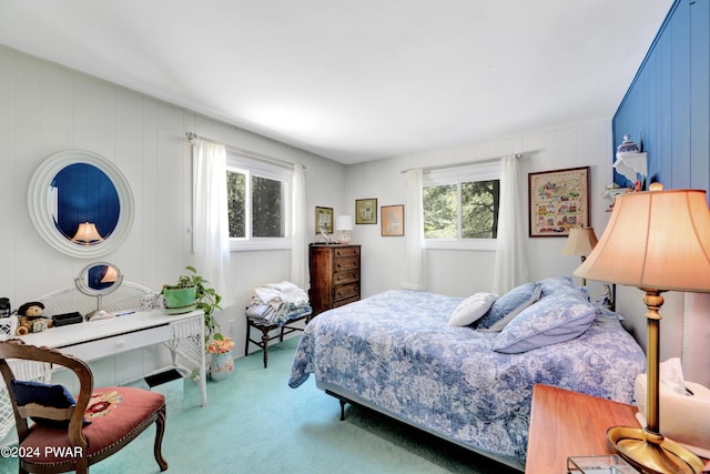 carpeted bedroom with wood walls and multiple windows