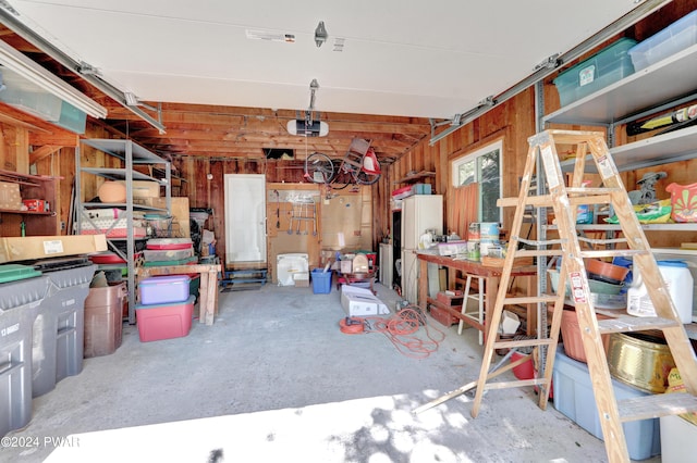 garage featuring white fridge and a garage door opener