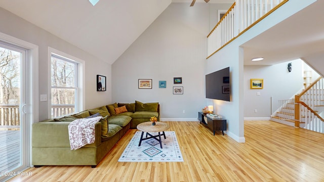 living room featuring light hardwood / wood-style flooring and high vaulted ceiling