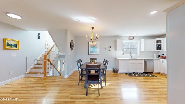 dining space with light wood-type flooring, a notable chandelier, and sink