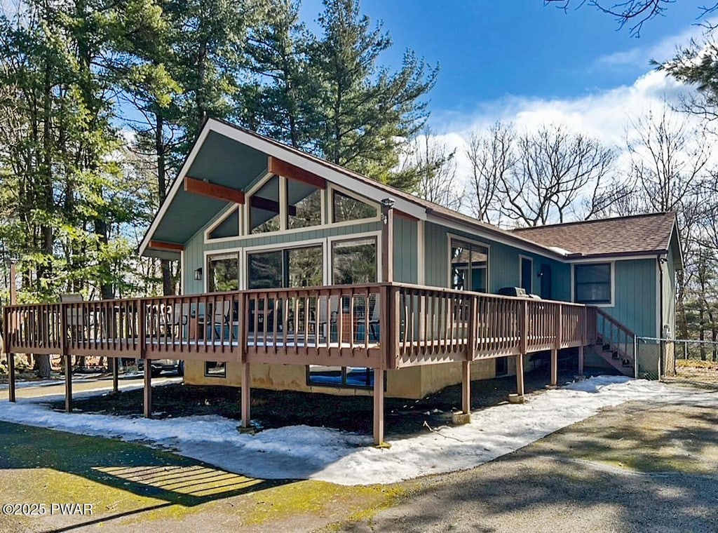 view of front of property featuring a shingled roof and a wooden deck