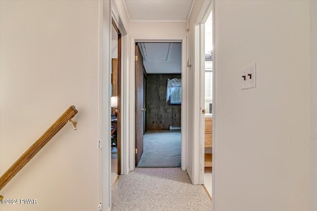 corridor with light colored carpet and a textured ceiling