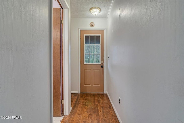 entryway featuring a textured ceiling, wood-type flooring, and ornamental molding