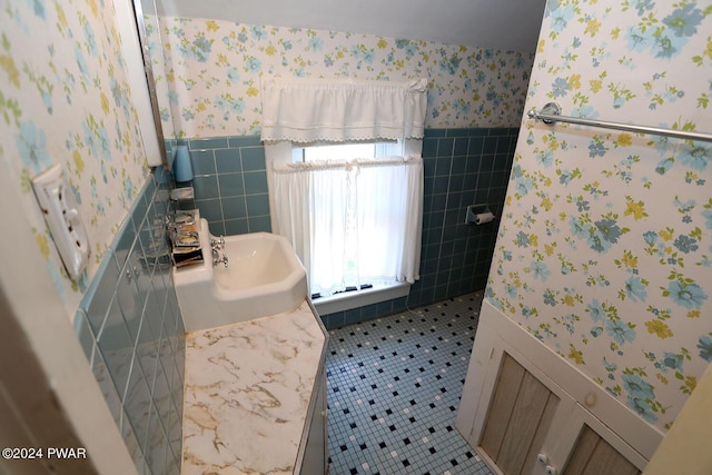 bathroom featuring tile patterned floors, sink, and tile walls