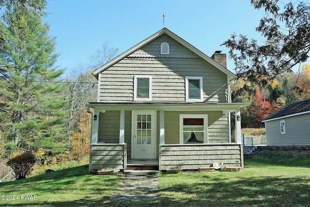 rear view of house featuring a porch and a yard