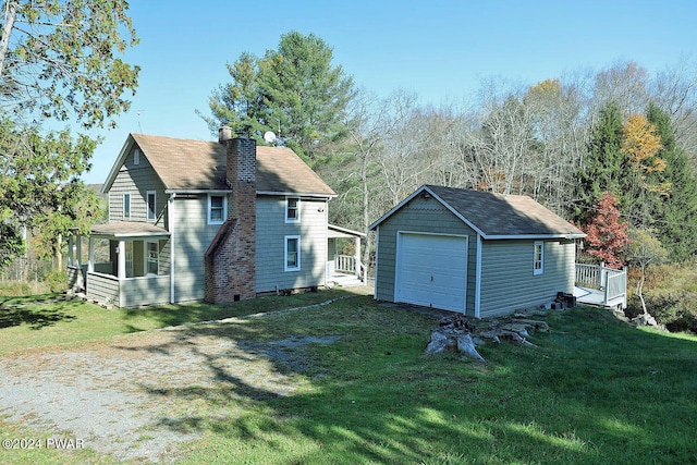 view of front facade with an outbuilding, a front yard, and a garage