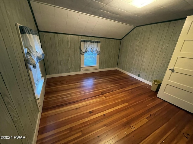 interior space with wood-type flooring, vaulted ceiling, and wooden walls