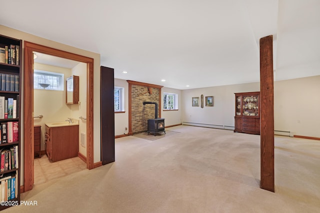 114 Wisener Ln, Shohola, PA 18458 - below grade area featuring a wealth of natural light, a wood stove, a baseboard radiator, and light colored carpet