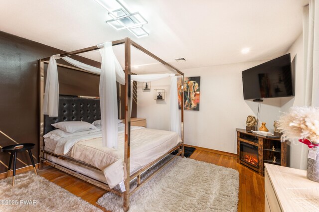 65 N Shore Dr, Albrightsville, PA 18210 - bedroom featuring visible vents, wood finished floors, and a glass covered fireplace