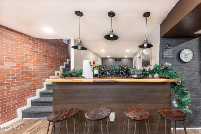 65 N Shore Dr, Albrightsville, PA 18210 - bar with wood finished floors, stairs, brick wall, decorative light fixtures, and a community bar