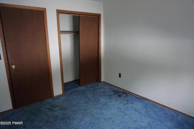 unfurnished bedroom with dark colored carpet and a closet