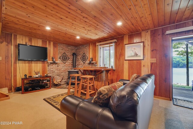 carpeted living room featuring wood walls, wood ceiling, and brick wall