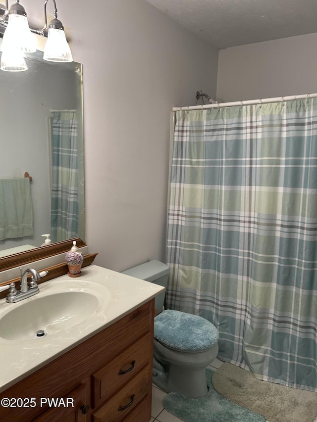 bathroom featuring a shower with curtain, vanity, toilet, and a textured ceiling