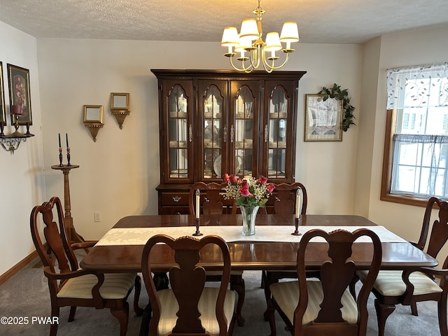 dining area featuring carpet, a textured ceiling, and a chandelier