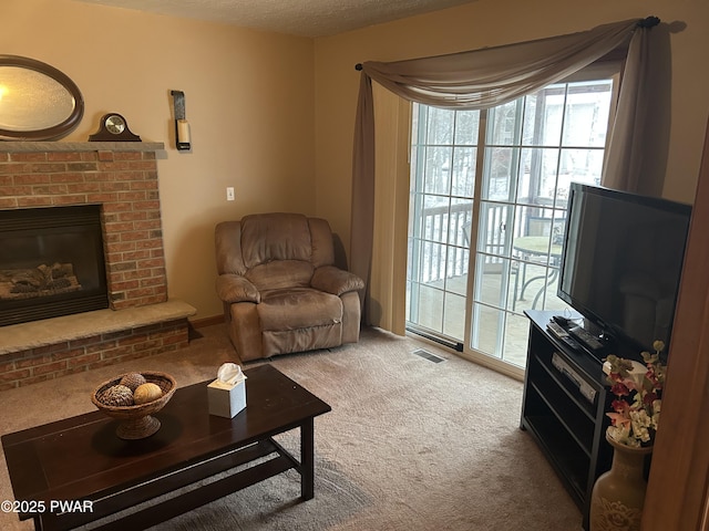 living room featuring carpet flooring, a textured ceiling, and a brick fireplace