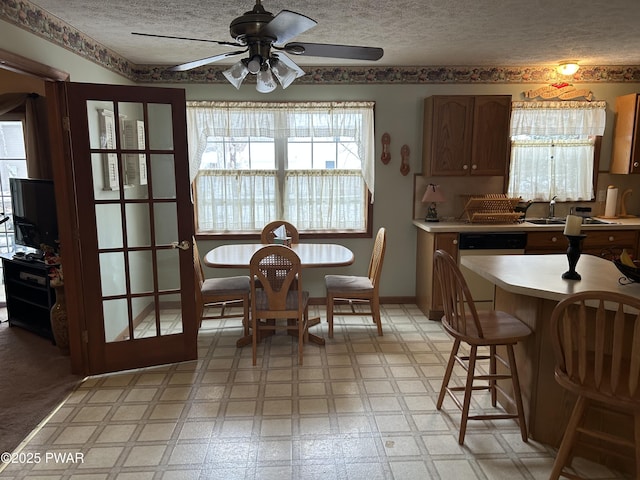 dining space with a textured ceiling, ceiling fan, and sink