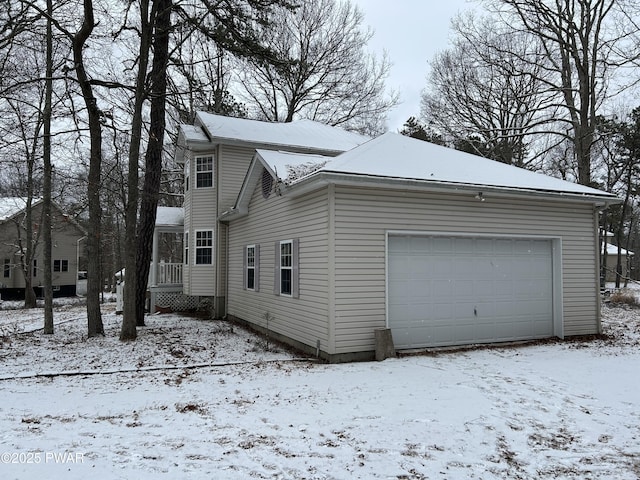 snow covered property with a garage