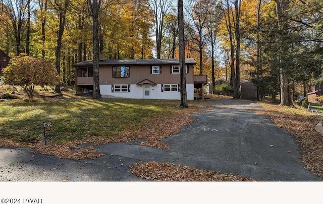 split foyer home featuring a shed and a front lawn