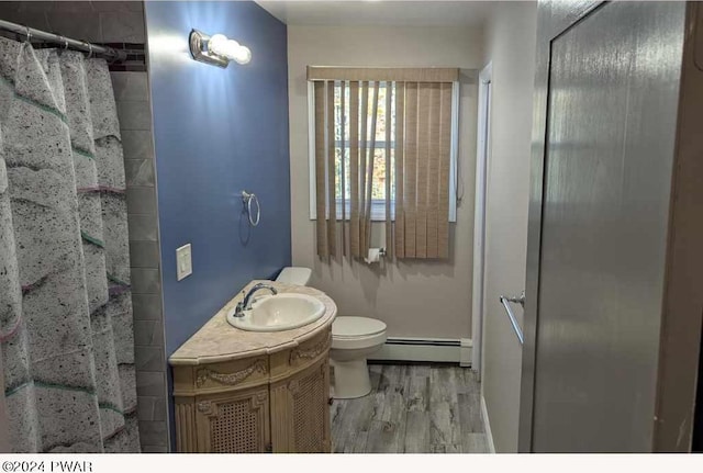 bathroom with vanity, a baseboard heating unit, hardwood / wood-style flooring, toilet, and curtained shower