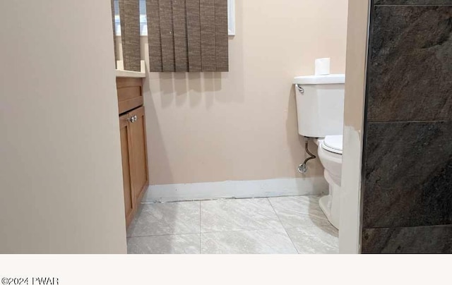 bathroom featuring tile patterned flooring, vanity, and toilet