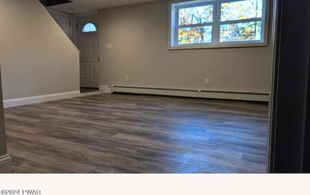 basement with baseboard heating and dark wood-type flooring